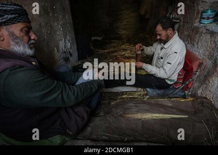 Idlib City, Syrie. 22 novembre 2020. Les travailleurs font des balais de paille faits à la main dans un petit atelier dans un quartier populaire de la ville d'Idlib. La fabrication de balais de paille a été active au cours des dernières années en raison de la dépendance des résidents au lieu des outils électriques en raison des coupures de courant. Credit: Aras Alkharboutli/dpa/Alamy Live News Banque D'Images
