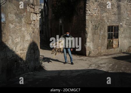 Idlib City, Syrie. 22 novembre 2020. Un ouvrier tient le sourcil pour faire des balais de paille faits à la main dans un petit atelier dans un quartier populaire de la ville d'Idlib. La fabrication de balais de paille a été active au cours des dernières années en raison de la dépendance des résidents au lieu des outils électriques en raison des coupures de courant. Credit: Aras Alkharboutli/dpa/Alamy Live News Banque D'Images