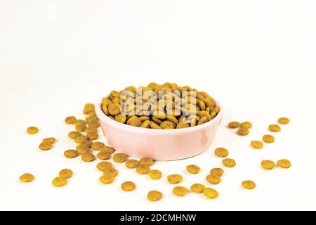 Animaux de compagnie chien chat nourriture sèche dans un bol rose sur fond blanc Banque D'Images