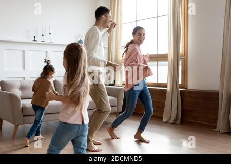 Les parents et les enfants jouent ensemble dans une maison moderne et chaleureuse Banque D'Images
