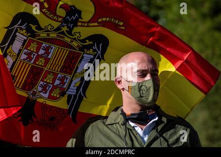 Madrid, Espagne. 22 novembre 2020. Un partisan d'extrême-droite de Franco portant un masque facial avec une image du dictateur alors qu'il fonde un drapeau pré-constitutionnel lors d'un rassemblement commémorant le 45e anniversaire de la mort de l'ancien dictateur espagnol Francisco Franco sur la Plaza de Oriente. Credit: Marcos del Mazo/Alay Live News Banque D'Images