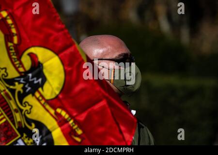 Madrid, Espagne. 22 novembre 2020. Un partisan d'extrême-droite de Franco portant un masque facial avec une image du dictateur alors qu'il fonde un drapeau pré-constitutionnel lors d'un rassemblement commémorant le 45e anniversaire de la mort de l'ancien dictateur espagnol Francisco Franco sur la Plaza de Oriente. Credit: Marcos del Mazo/Alay Live News Banque D'Images