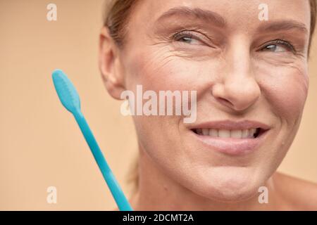 Femme mûre souriante qui va se brosser les dents Banque D'Images