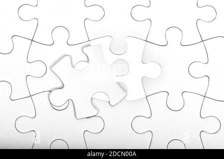 Fond blanc de motif de puzzle. Placement de la dernière pièce de puzzle Banque D'Images