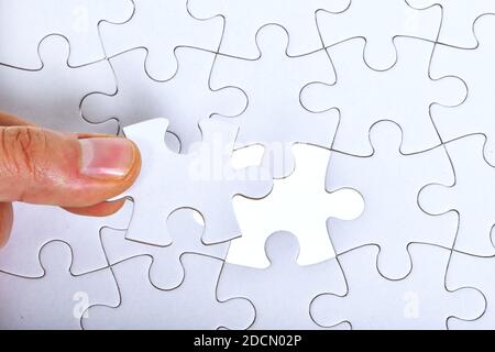 Fond blanc de motif de puzzle. Placement de la dernière pièce de puzzle Banque D'Images