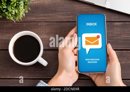 Une jeune femme méconnue vérifie sa boîte de réception messages électroniques entrants à la réception pendant la pause café Banque D'Images