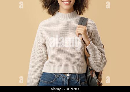 Joyeuse femme afro-américaine millénaire en chandail et verres avec sac à dos Banque D'Images