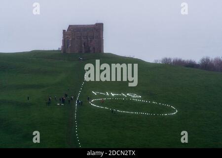 Abbotsbury, Dorset, Royaume-Uni. 22 novembre 2020. Météo au Royaume-Uni : l’événement caritatif annuel bougies sur la colline à la chapelle St Catheine’s Chapel à Abbotsbury, dans le Dorset, se poursuit au crépuscule avec le NHS écrit dans des lumières au-dessus du cercle de lumière sur le chemin menant à la chapelle pendant le confinement de Covid-19, lors d’une soirée de drizzly. Crédit photo : Graham Hunt/Alamy Live News Banque D'Images