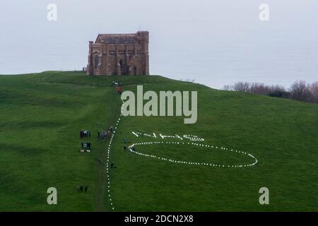 Abbotsbury, Dorset, Royaume-Uni. 22 novembre 2020. Météo au Royaume-Uni : l’événement caritatif annuel bougies sur la colline à la chapelle St Catheine’s Chapel à Abbotsbury, dans le Dorset, se poursuit au crépuscule avec le NHS écrit dans des lumières au-dessus du cercle de lumière sur le chemin menant à la chapelle pendant le confinement de Covid-19, lors d’une soirée de drizzly. Crédit photo : Graham Hunt/Alamy Live News Banque D'Images