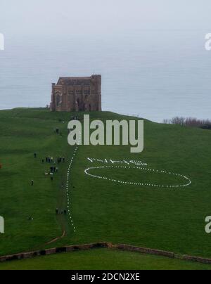 Abbotsbury, Dorset, Royaume-Uni. 22 novembre 2020. Météo au Royaume-Uni : l’événement caritatif annuel bougies sur la colline à la chapelle St Catheine’s Chapel à Abbotsbury, dans le Dorset, se poursuit au crépuscule avec le NHS écrit dans des lumières au-dessus du cercle de lumière sur le chemin menant à la chapelle pendant le confinement de Covid-19, lors d’une soirée de drizzly. Crédit photo : Graham Hunt/Alamy Live News Banque D'Images