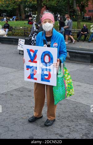 NEW YORK - le 24 octobre 2020 : une femme plus âgée porte un panneau de vote 2020 dans le parc. Banque D'Images