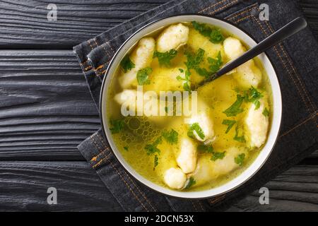 Griessnockerlsuppe bœuf et semoule soupe de boulettes gros plan dans une assiette sur la table. Vue horizontale du dessus Banque D'Images