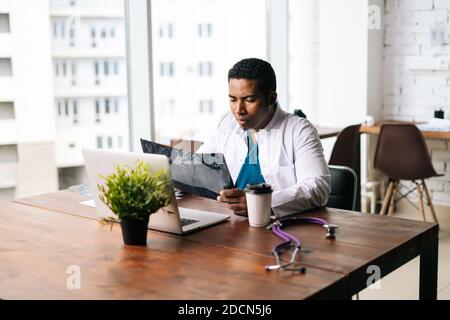Un médecin afro-américain qualifié portant un costume de chirurgien médic étudiant antécédents de maladie du patient Banque D'Images