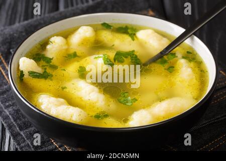 Griessnockerlsuppe bœuf et semoule soupe de boulettes gros plan dans une assiette sur la table. Horizontale Banque D'Images