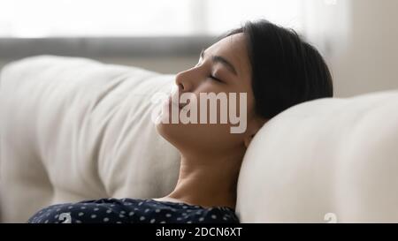 Gros plan calme et tranquille jeune femme asiatique se reposant sur un canapé Banque D'Images