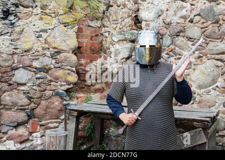 Vieux casque de chevalier médiéval et de la chaîne du courrier pour la protection dans la bataille. Coiffure très lourd sur le stand dans la nature. Moyen âge armor concept Banque D'Images