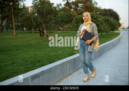 Étudiante arabe avec ordinateur portable dans le parc Banque D'Images