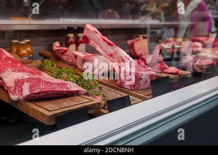 Foyer sélectif et vue de face du rouge frais cru bonne qualité de la viande à travers le verre du comptoir à la boucherie. Banque D'Images