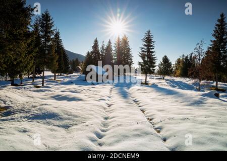 Soleil sur la maison de village pendant l'hiver, Slovénie Banque D'Images