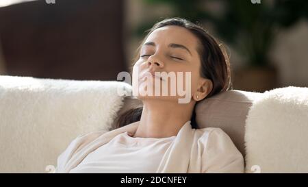 Une jeune femme fatiguée se reposant sur un canapé et se lasse après une journée de travail Banque D'Images