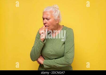 La femme âgée se sent mal et tousse comme symptôme de rhume ou de bronchite. Concept de soins de santé. Banque D'Images