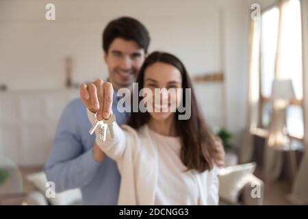 Heureux couple acheteurs d'appartement posant avec les clés dans les mains Banque D'Images