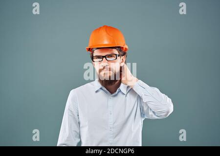 Homme en orange casque chemise court vue sur fond bleu travaux de construction Banque D'Images