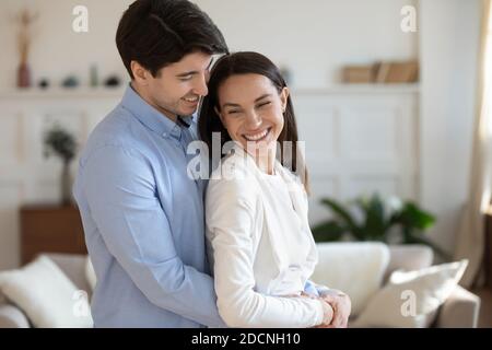 Affectueux et affectueux mari millénaire tenant une femme bien-aimée dans les bras Banque D'Images