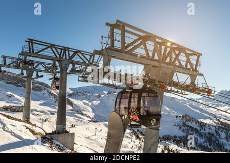 Ischgl, Autriche - 10 janvier 2020 : nouvelle télécabine spacieuse et moderne Silvretta bahn contre pied de remontée mécanique avec engrenages à roulettes et soleil rétro-éclairé Banque D'Images