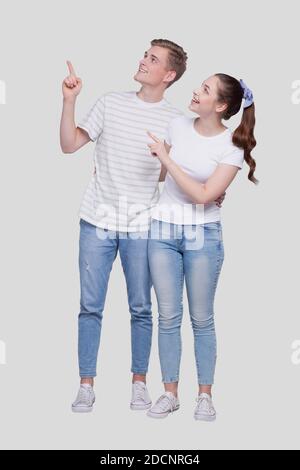 Couple pointant vers le haut debout isolé. Homme et femme pointant, amoureux, amis, couple concept Banque D'Images