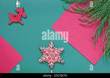 plat de noël avec ornements en bois et branches de genévrier vertes arrière-plan en papier coloré Banque D'Images
