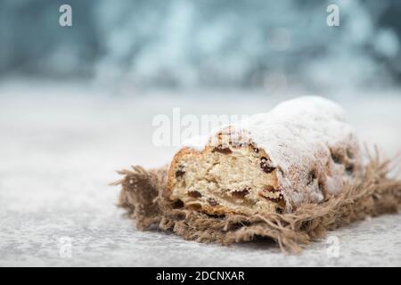 Christstollen, gâteau de noël traditionnel aux noix, raisins secs, massepain sur fond bleu, espace vide pour le texte Banque D'Images