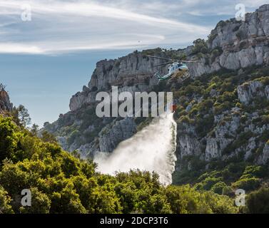 Bomberos (pompiers) a incendié à Canuto de la Utrera, en utilisant un seau d'eau sur un hélicoptère Banque D'Images