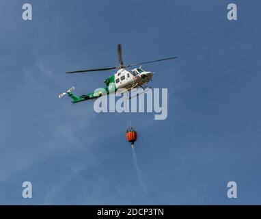 Bomberos (pompiers) a incendié à Canuto de la Utrera, en utilisant un seau d'eau sur un hélicoptère Banque D'Images