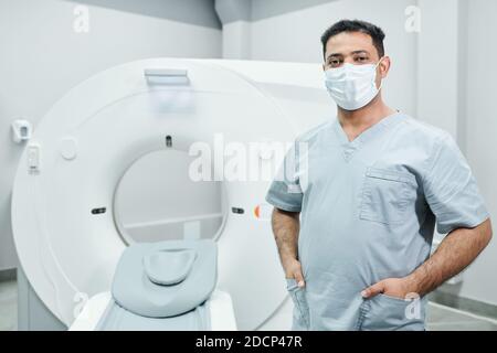 Jeune homme de race mixte réussi docteur en masque de protection et uniforme Banque D'Images
