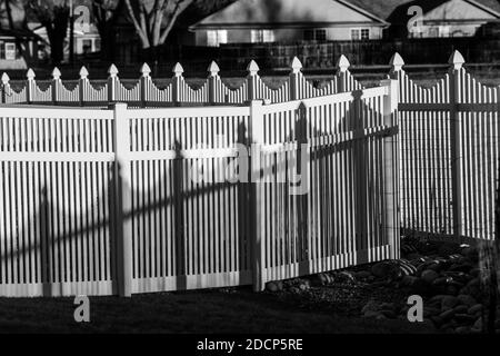 Vue en noir et blanc de la clôture et des ombres en vinyle blanc; Salida; Colorado; États-Unis Banque D'Images