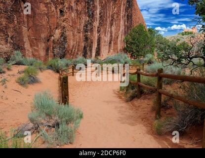 Randonnée sur un sentier dans le parc national d'Arches, Utah Une journée d'été ensoleillée avec UN ciel bleu clair et Quelques nuages Banque D'Images