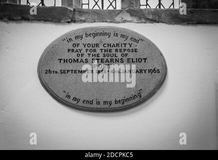 Fenêtres en verre plombées au-dessus d'une plaque commémorative inscrite pour le poète TS Eliot à l'intérieur de St. Michael's et de l'église All Angeles à East Coker, Somerset, Angleterre Banque D'Images