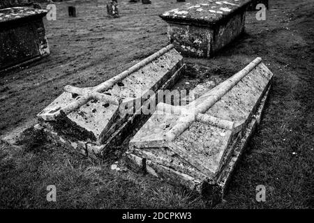 Style insolite de Twin Lawn Crypts dans un cimetière paroissial de l'ancien monde à l'église St Michael & All Angels dans le village d'East Coker, Angleterre, Royaume-Uni, B&W. Banque D'Images