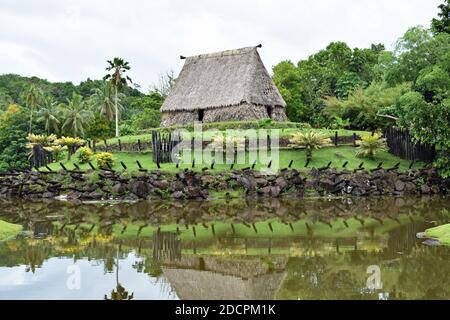 Le Bure Kalau (maison d'esprit) au Pacific Harbour Arts Village près de Suva aux Fidji. La maison est et la verdure se reflète dans un petit lac. Banque D'Images