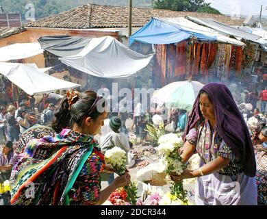 Deux femmes travaillent avec des fleurs dans le marché historique de Chichi, un marché maya coloré à Chichichasenango, au Guatemala. Banque D'Images