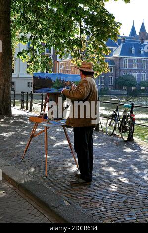 Un artiste hollandais peint dans des huiles sur un chemin pavé. Banque D'Images