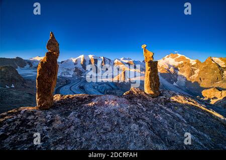 Deux rochers cairns sur un rocher, les sommets de Piz Palü, Bella Vista et Piz Bernina et la partie supérieure du glacier pers, vus de Munt pers près de Diavolezz Banque D'Images