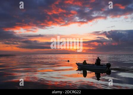 Mudeford, Dorset. 23 novembre 2020. Météo Royaume-Uni. Un lever de soleil spectaculaire tandis que les pêcheurs quittent Mudeford Quay à Dorset. Credit Stuart Martin/Alay Live News Banque D'Images