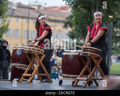 Girsl jouant des tambours de la tradition musicale japonaise lors d'un événement public en plein air. Banque D'Images