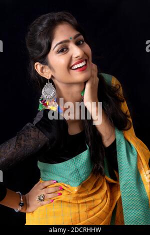 Femme indienne en jaune sari souriant devant l'appareil photo. Heureux Banque D'Images