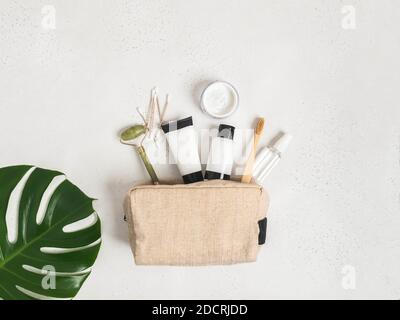 Sac de voyage écologique avec les moyens nécessaires pour prendre soin de la peau des femmes. Cosmétiques, masseur avec cristaux, shampooing sec, coton-tiges, brosses à dents i Banque D'Images