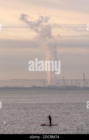 Southend on Sea, Essex, Royaume-Uni. 23 novembre 2020. Le jour a dawed lumineux mais froid. Une paddle boarder solitaire est sur l'estuaire de la Tamise. La vapeur s'élève de la centrale de grain dans le Kent Banque D'Images