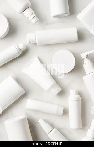 Vue de dessus des bouteilles vierges et des bocaux de différentes peaux produits d'entretien pour le bain de routine placés sur une table en marbre blanc Banque D'Images