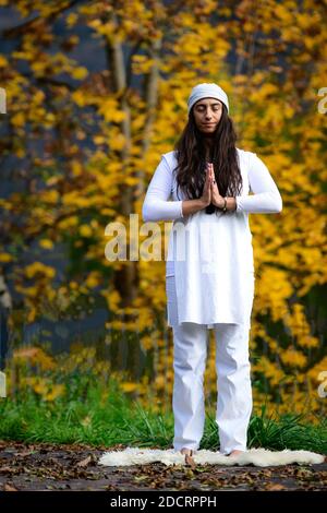 Femme en blanc pratique le yoga dans la nature en automne Banque D'Images